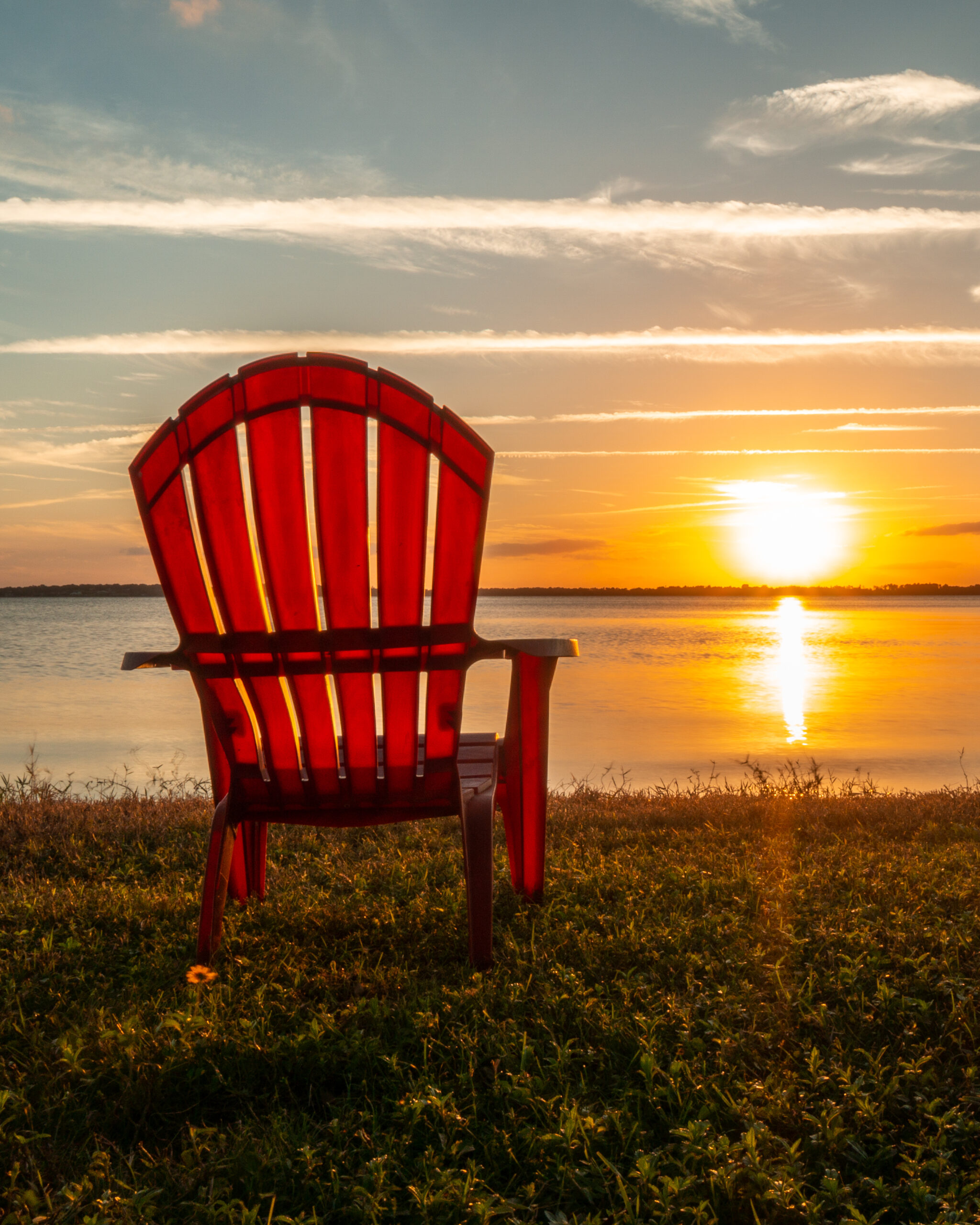 l sunset and a beach chair overlook the stunning Lake Minnehaha in Clermont, FL